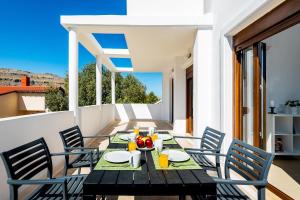 a wooden table and chairs on a balcony with a view at Aggellina Villa in Pefki Rhodes
