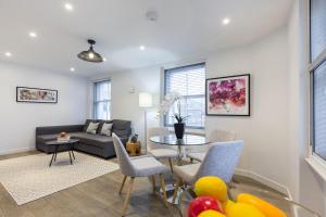 ein Wohnzimmer mit einem Sofa und einem Tisch in der Unterkunft Urban Chic - Rathbone in London