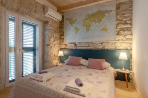 - une chambre avec un grand lit et une carte murale dans l'établissement Traditional stone house with swimming pool, à Lumbarda