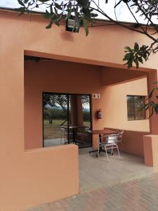 a view of the outside of a house with a table and chairs at Rondy Bosch Lodge in Louis Trichardt