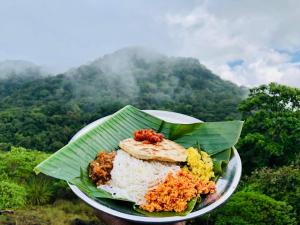 einen Teller mit Reis und Gemüse auf einem Bananenblatt in der Unterkunft Eco Village Kalundewa in Dambulla