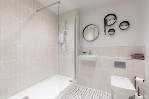 a bathroom with a shower and a toilet and a sink at Elliot Oliver - Luxury 2 Bedroom Regency Apartment With Parking & EV Charger in Cheltenham