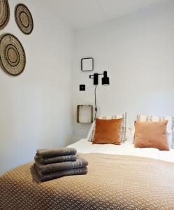 a bedroom with a bed with towels on it at Luxe Tiny House op de Veluwe in Nunspeet