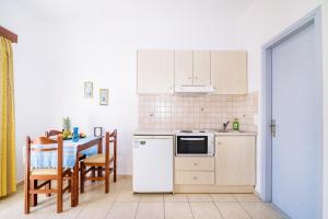 a kitchen with a table and a white refrigerator at Kalyves Bay in Kalyves