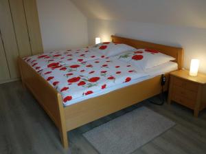 ビューズムにあるHaus Leißnerのベッドルーム1室(赤い花のベッド1台付)
