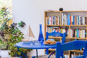 une table bleue avec une assiette de pain et une étagère à livres dans l'établissement Kalyves Bay, à Kalyves
