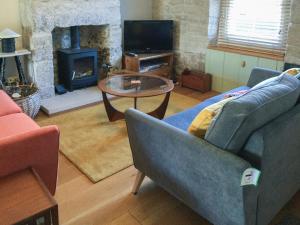 Lime Cottage في بورتلاند: غرفة معيشة مع أريكة وطاولة ومدفأة