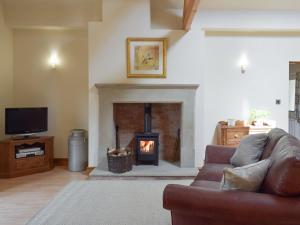 a living room with a couch and a fireplace at Woodpecker Cottage - Ukc3412 in Bolton by Bowland