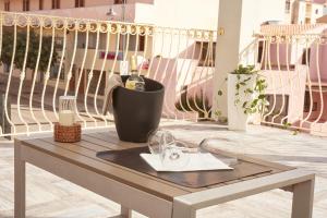 uma mesa com uma garrafa de vinho na varanda em Hotel Muita di Mari em Santa Teresa Gallura