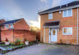 a brick house with a white door and a brick driveway at Pass the Keys Beautiful Cosy Home in Basildon