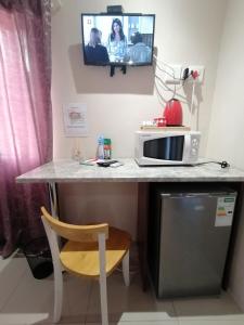 a desk with a microwave and a tv on the wall at Rondy Bosch Lodge in Louis Trichardt