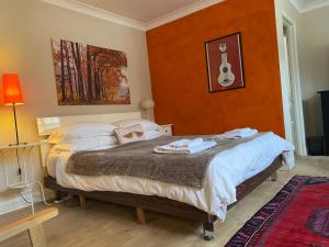 a bedroom with a bed with a guitar on the wall at Rural House near Bramley in Guildford