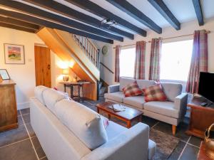 a living room with two couches and a tv at Alwyn Cottage in Llangollen