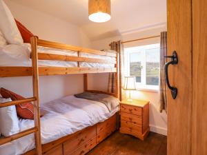 a bedroom with two bunk beds and a window at Alwyn Cottage in Llangollen