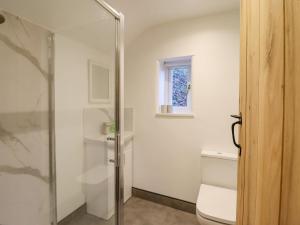 a bathroom with a toilet and a glass shower at Alwyn Cottage in Llangollen +25 photos