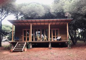 eine kleine Hütte mit einer Veranda und Stühlen im Wald in der Unterkunft miCielo - Baumhäuser in Vejer de la Frontera