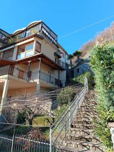 a building on a hill with stairs leading to it at Patty ZU - Lakeside apartment in Riva di Solto