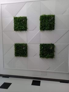 a wall with green plants on it at Apartament 2 dormitoare și living bloc nou in Năvodari