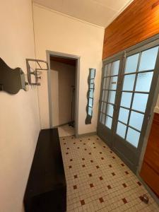 een lege kamer met een deur en een tegelvloer bij LE LOFT et le T2, Le Mont Dore, au pied de La Dordogne in Le Mont-Dore