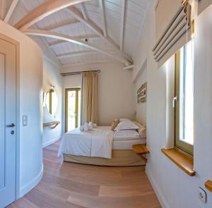 a bedroom with a white bed and a window at Stargaze Villas in Panormos Skopelos