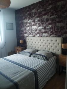 a bedroom with a bed with a wallpaper with animals at L'Olivier in Beuzeville