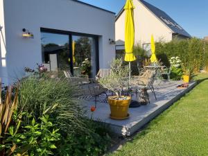 a patio with a table and a yellow umbrella at L'Olivier in Beuzeville