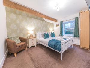 a bedroom with a bed and a chair and a window at Lakeland View in Keswick