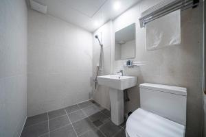 a bathroom with a white toilet and a sink at Jawoori Hotel Incheon Songdo in Incheon