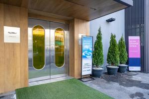 a front door of a building with potted trees at Jawoori Hotel Incheon Songdo in Incheon