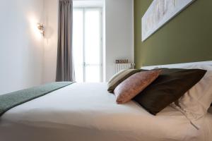 Un dormitorio con una cama con almohadas. en Casa del Monumento del Re by Wonderful Italy en Turín