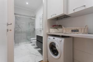 a white laundry room with a washer and dryer at Casa del Monumento del Re by Wonderful Italy in Turin