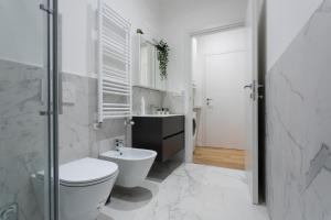 a white bathroom with a toilet and a sink at Casa del Monumento del Re by Wonderful Italy in Turin +8 photos