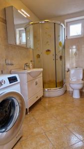a bathroom with a shower and a washing machine at Apartmani Marija in Baška