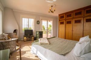 a bedroom with a bed and a chair and a television at Casa Ancladero Room W big balcony and lovely view in Fuengirola