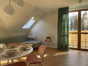 a living room with a couch and a table and chairs at Apartamenty Paproć i Malina - 300 metrów do centrum in Karpacz