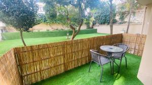 a patio with two chairs and a table and a fence at BayMari Suites Plus Florya in Istanbul