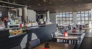 ein Restaurant mit Tischen und Stühlen und einer Bar in der Unterkunft Fly Bike Hotel in Trient