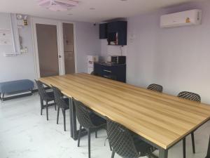 a large wooden table in a room with chairs at Spark Hotel - MRT Queen Sirikit - SHA Extra Plus Certified in Bangkok