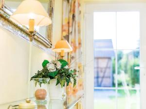 een tafel met een lamp en een vaas met bloemen bij Ferienhaus Sükow in Perleberg