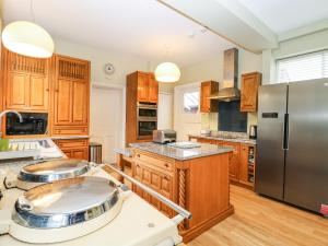 a kitchen with wooden cabinets and a stainless steel refrigerator at Croylands in North Walsham