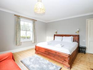 a bedroom with a bed and a red couch at Croylands in North Walsham
