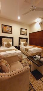 Park View Hotel Gulberg في لاهور: غرفة كبيرة بسريرين وطاولة