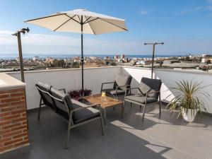a patio with a table and chairs and an umbrella at Villa Maritim in Torrox