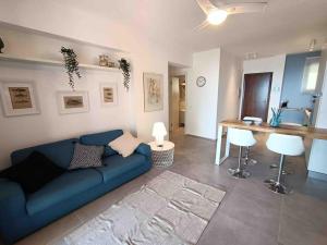 a living room with a blue couch and a table at Blue Holiday da Carla in Letojanni