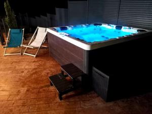 een grote jacuzzi met stoelen in een kamer bij L'écrin de Xattys - Gîte de standing-SPA-terrain de pétanque-Piscine-Switch-Baby-foot au coeur du Massif Vosgien in Cleurie