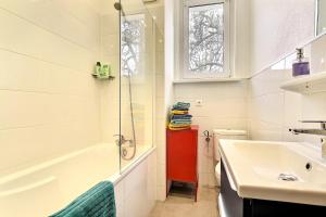 a bathroom with a tub and a sink and a shower at "Urbaine Colors" Appartement coloré et lumineux "Les Péri-Urbaines" in Riedisheim +26 photos