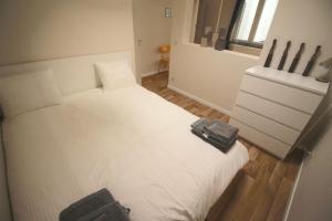 uma cama branca num quarto com uma janela em Charmant appart 2 ch avec terrasse en centre ville em Liège