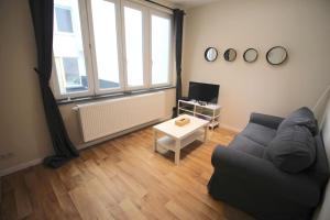uma sala de estar com um sofá e uma mesa em Charmant appart 2 ch avec terrasse en centre ville em Liège