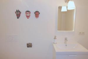 a bathroom with masks on the wall next to a sink at Charmant appart 2 ch avec terrasse en centre ville in Liège