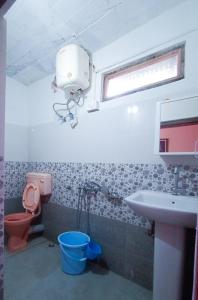 a bathroom with a sink and a toilet and a window at Aakeet Lyang Homestay in Kurseong